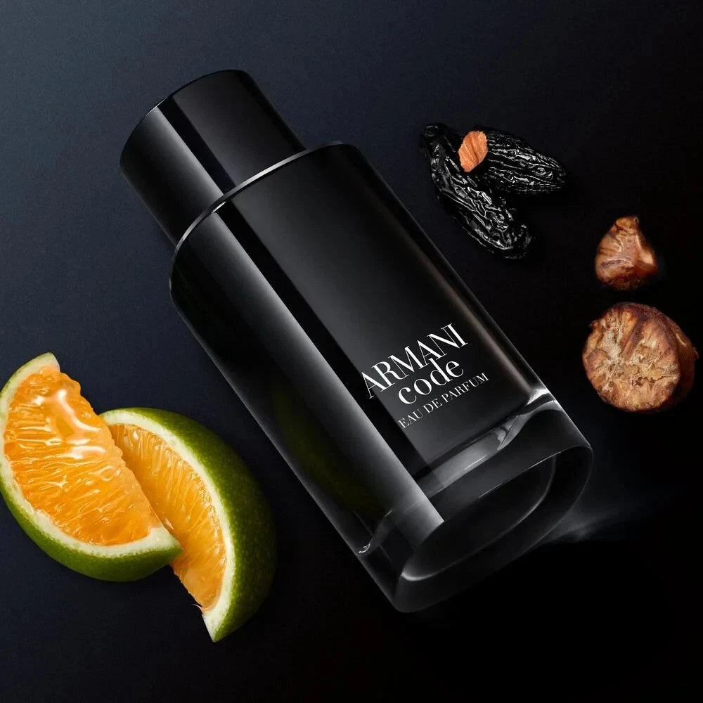 Black Armani Code perfume bottle with fruit slices and spices on a dark background